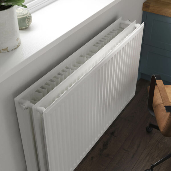 Stelrad K3 radiator positioned against a grey wall in an home office room