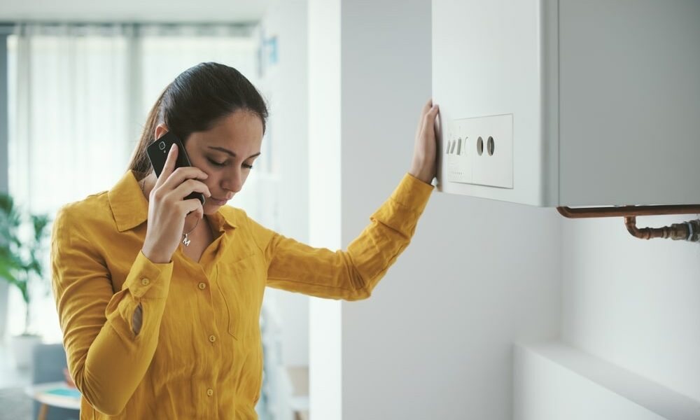 woman with a broken boiler phoning for help