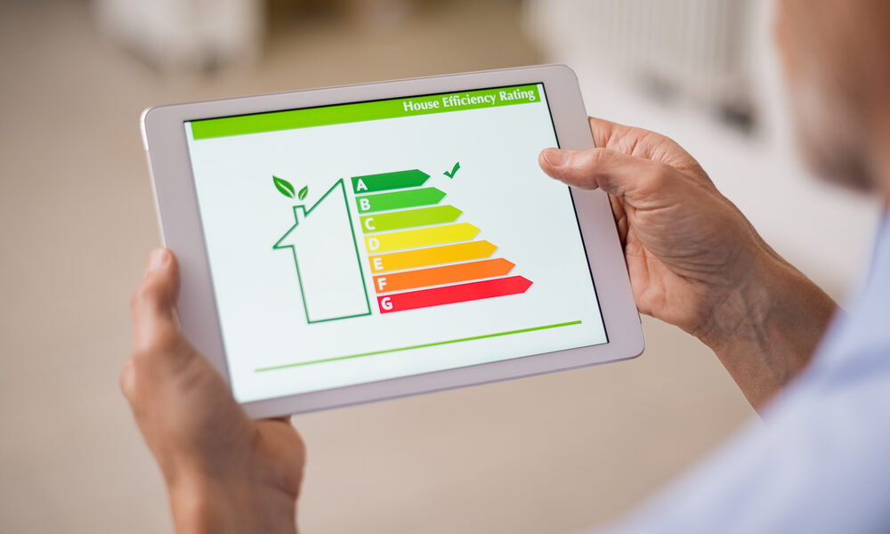 a man looking at an energy efficiency scale on a tablet computer