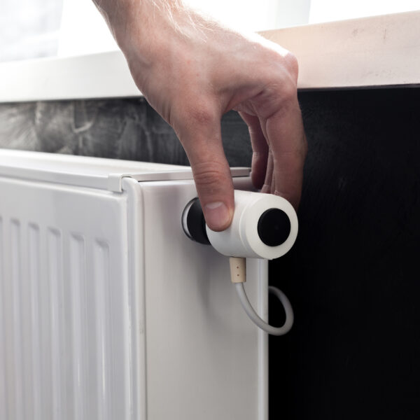 A hand adjusting the temperature on an electric radiator